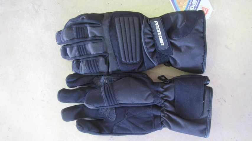 pair of black gloves laying on carpeted floor next to magazine