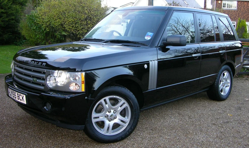 an black and silver range rover in front of a brick building