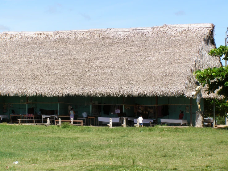 two people are sitting at the picnic tables under the roof of a building