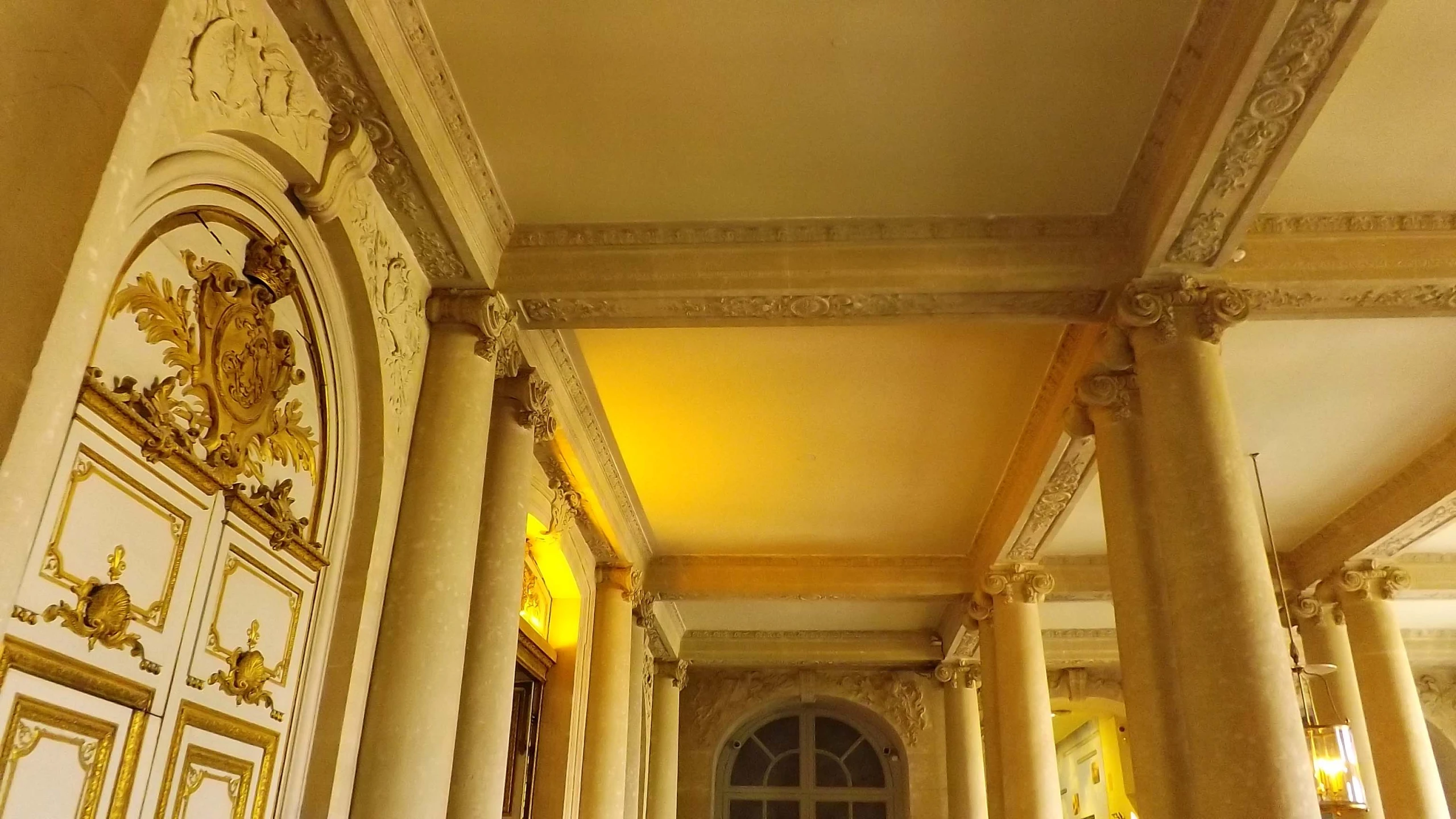 there is a hallway with marble walls and columns in it