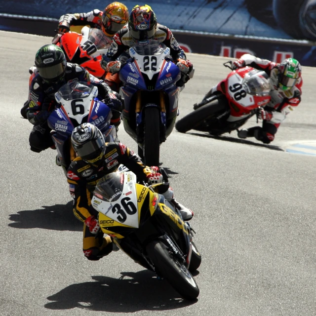 the motorcycle racers are racing on the track together