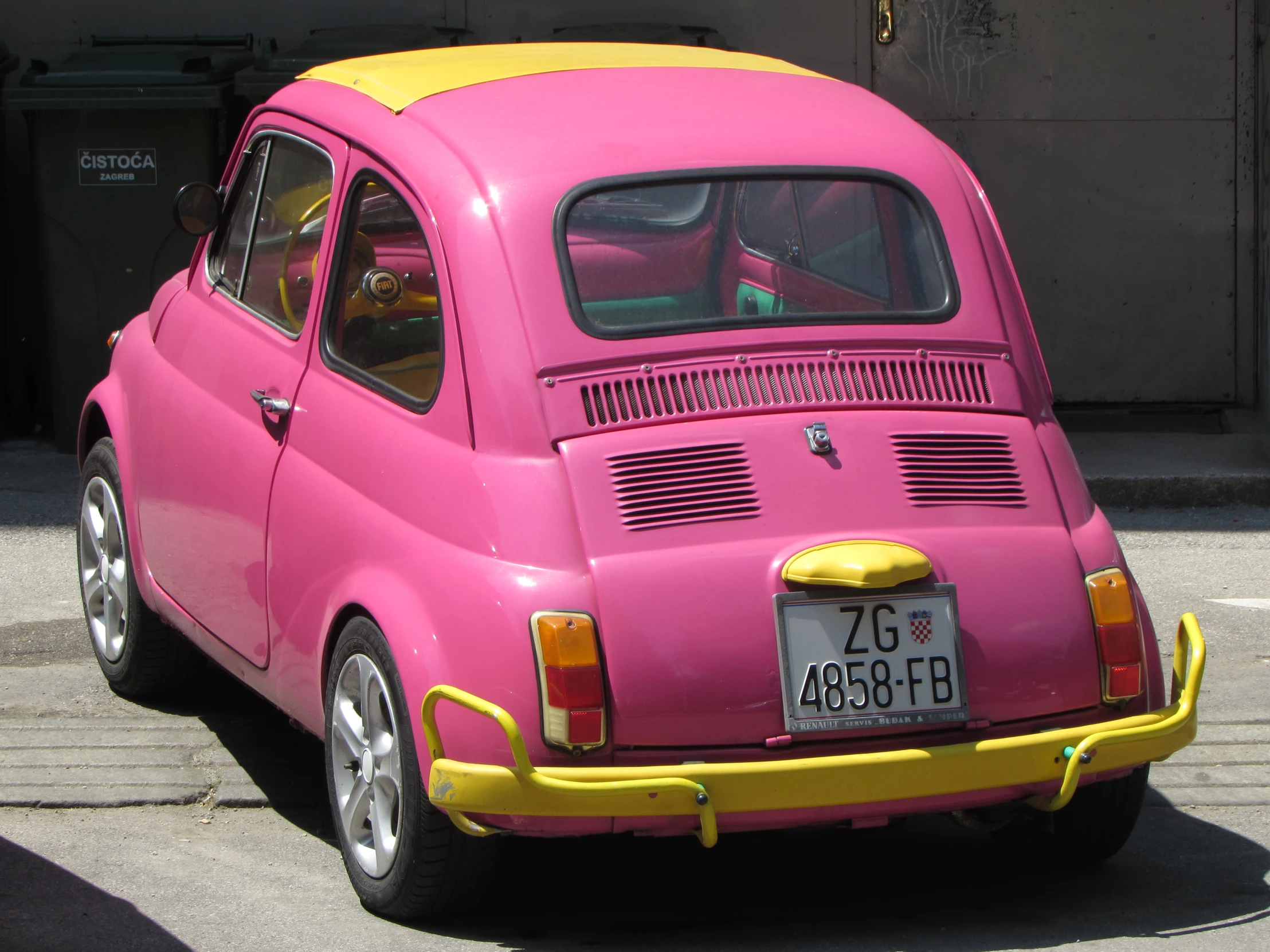 a small pink car with a yellow rear bumper strip