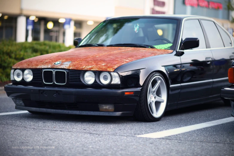 an odd looking rusty car sitting in a parking lot