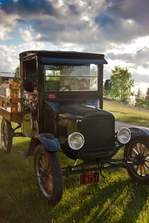 an old car is parked in the grass