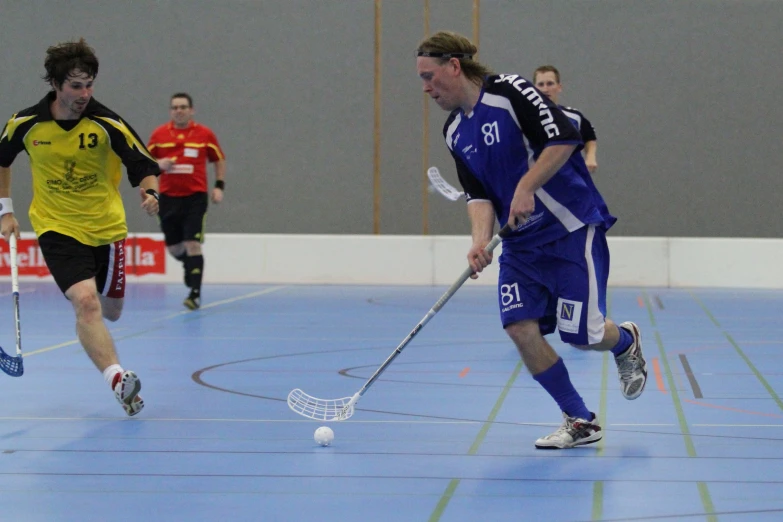 two men running down the court during a game of hockey