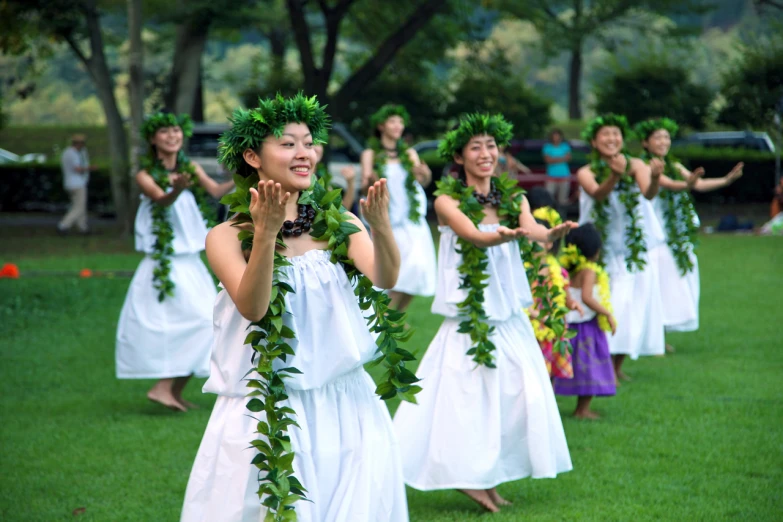 a group of women dancing and wearing garlands