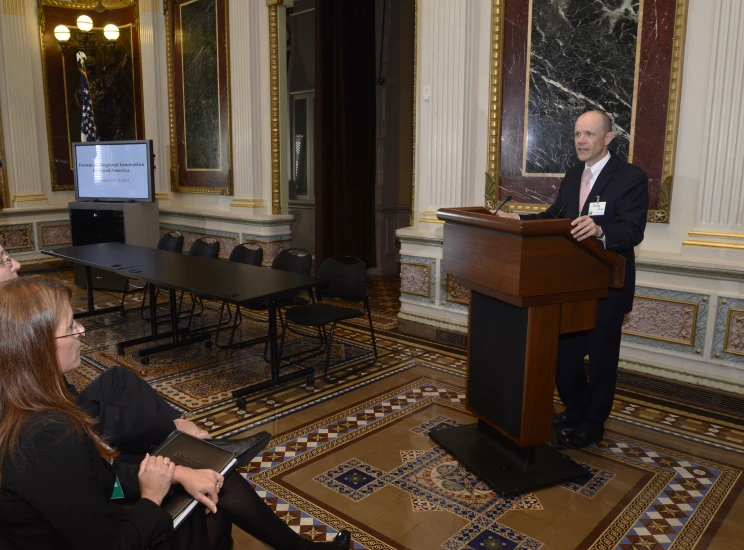 the man is talking to the audience from behind a podium