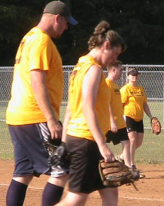 the girls are wearing gloves during a baseball game