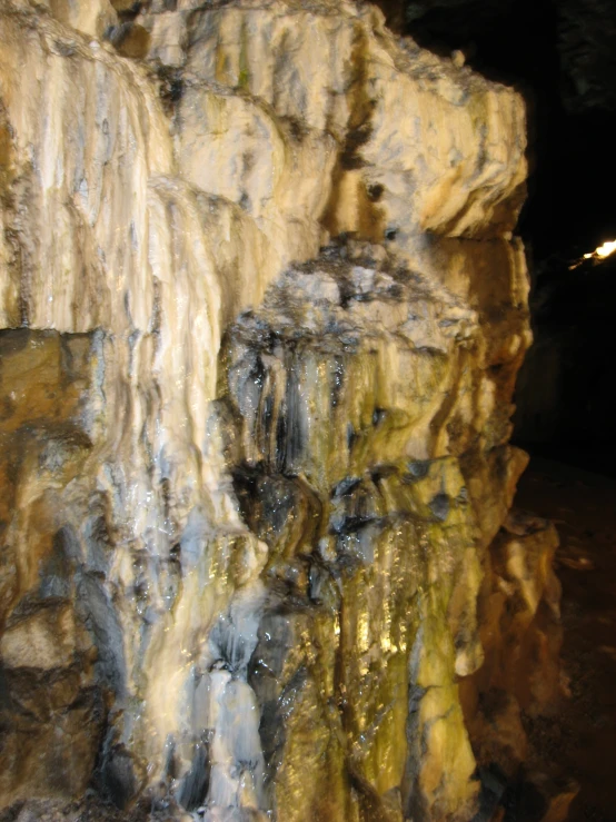 a small group of water flowing down rocks into a cave