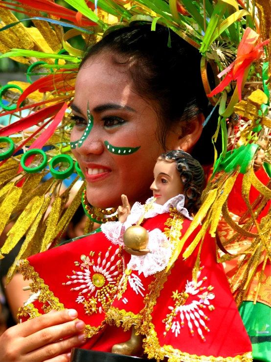 a young woman wearing headgear and feathers and green painted eyes