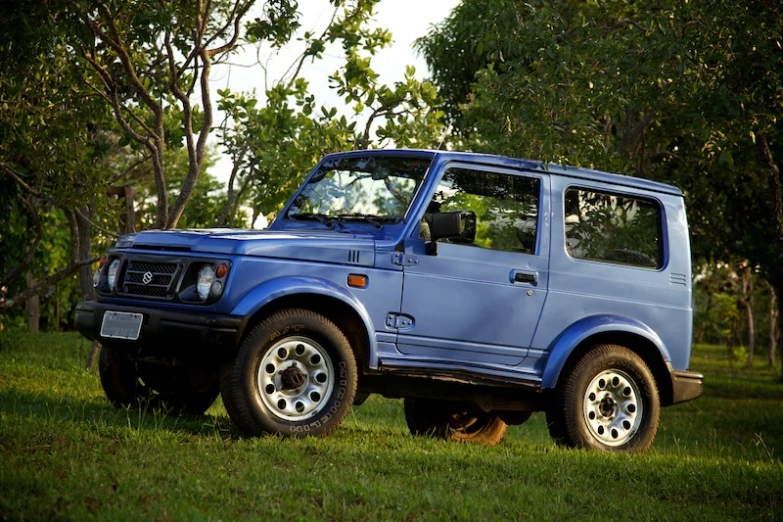 a blue truck parked in the middle of the forest