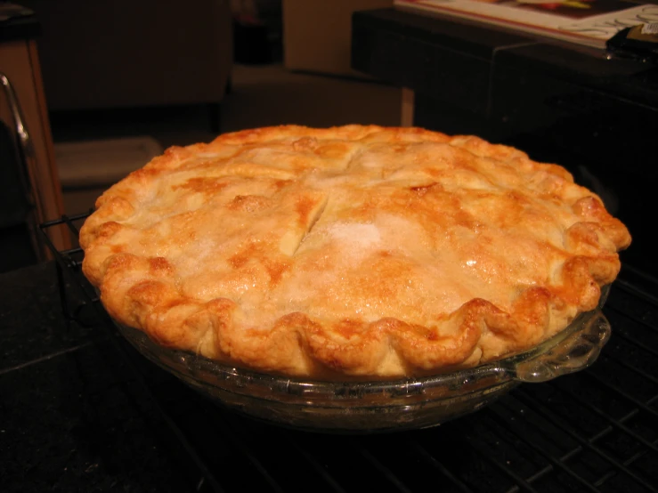 an unbaked pie sitting on the grill in a kitchen