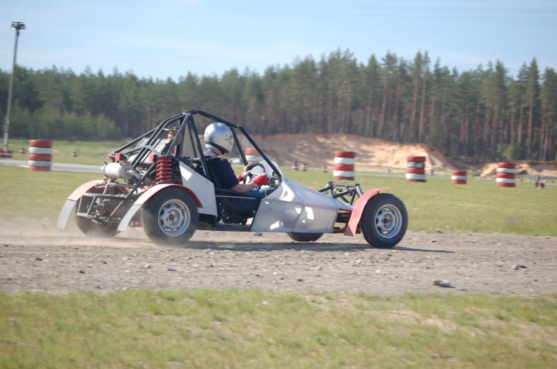 a person is in an open - air vehicle on a dirt road