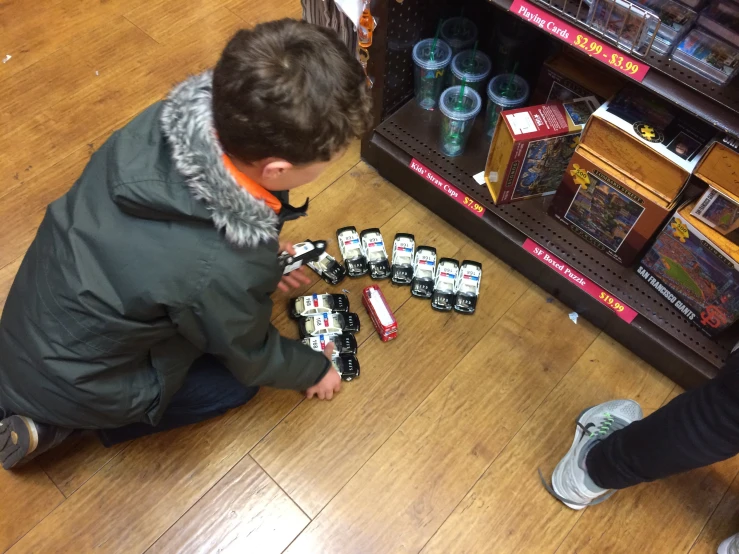 two boys are playing with toys on the floor