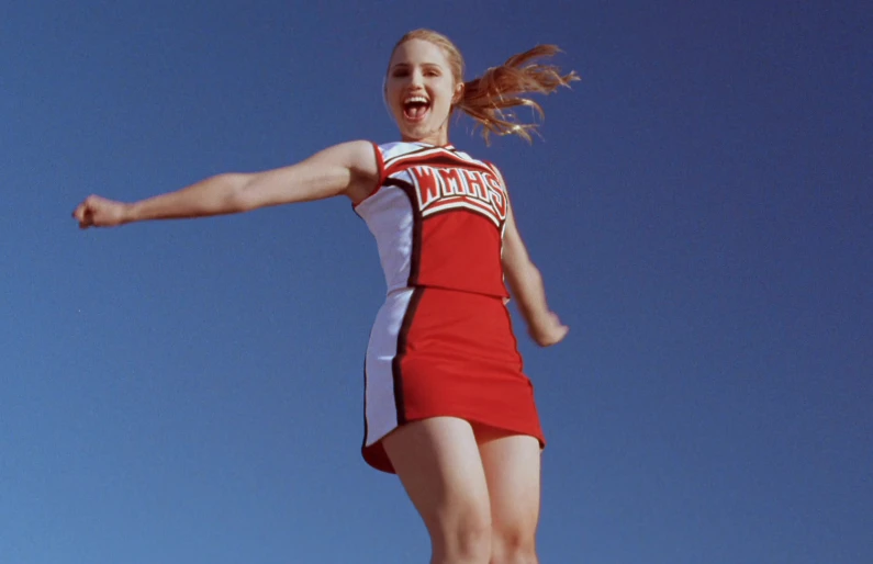 the woman in a short red and white cheerleader costume is happy