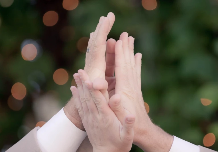 the hands of two people are folded in prayer