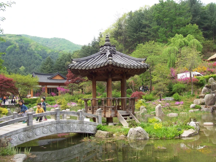 a scenic garden area with a pond and a small pagoda