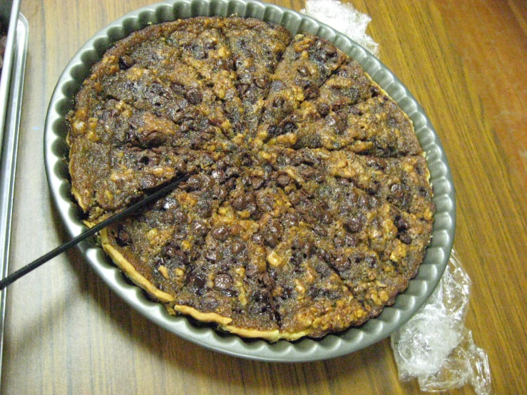 a pie sitting on top of a pan on a wooden table