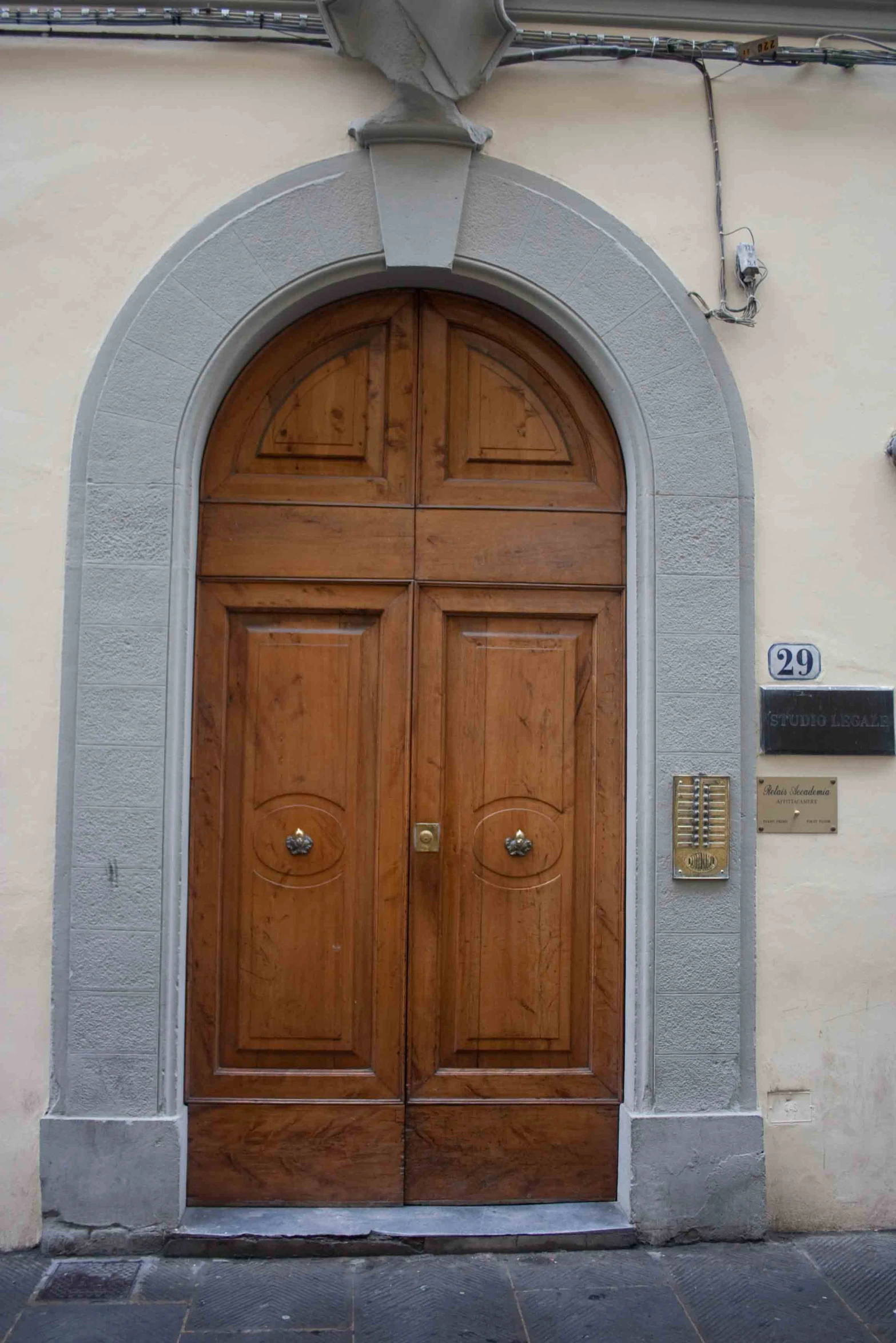 two wooden doors with numbers on them on a beige building