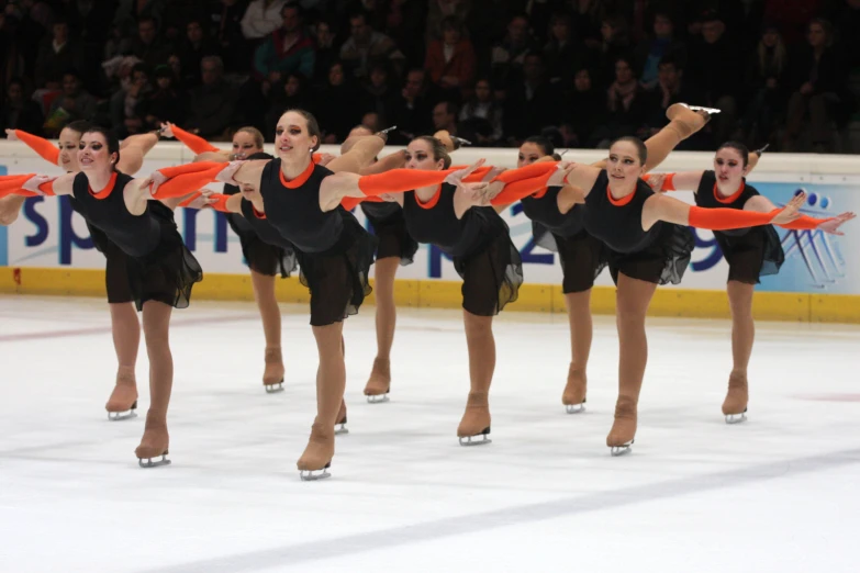 six female figure performs on the ice for the camera