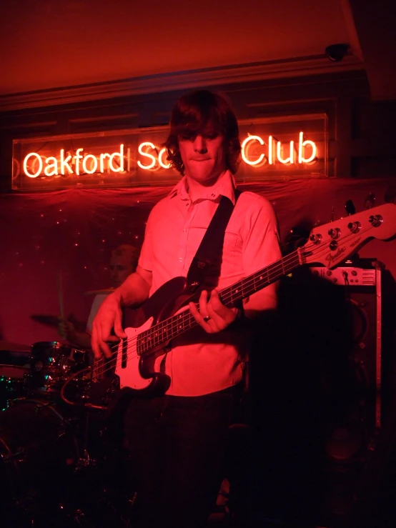 a man standing in front of a sign with a guitar