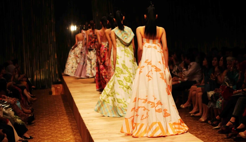 a fashion show with a few different dresses on a runway