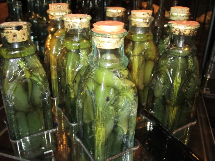 several green glass bottles filled with green veggies