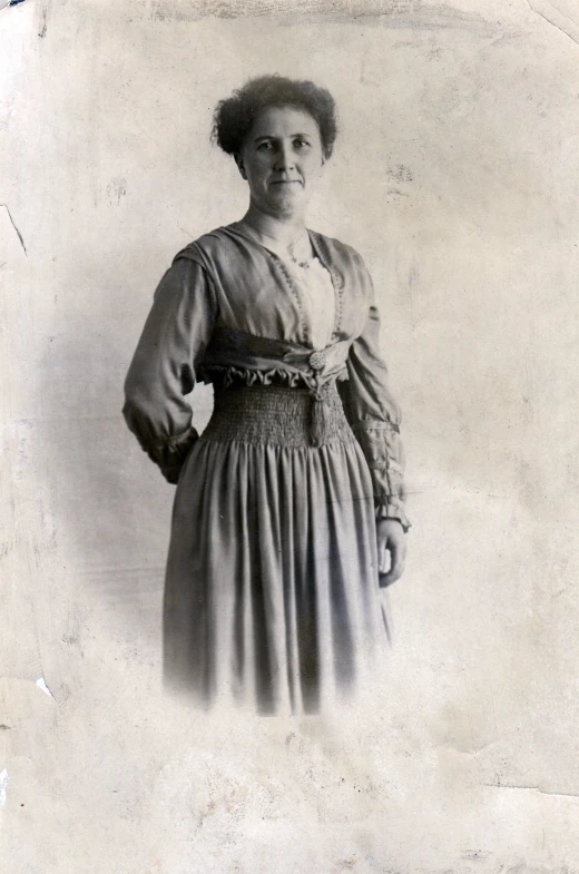 a woman in dress with long sleeves, wearing a necklace