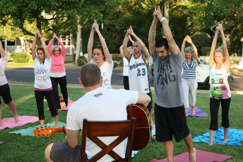 a group of people doing yoga exercises in the park