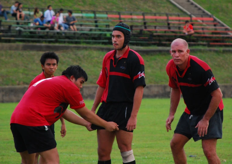 a group of men standing around each other on a field