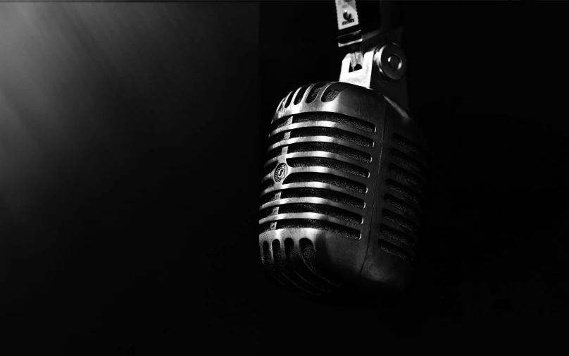 an old fashioned microphone hanging in a dark room