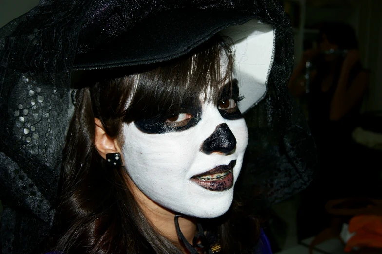 a woman with white makeup is wearing black