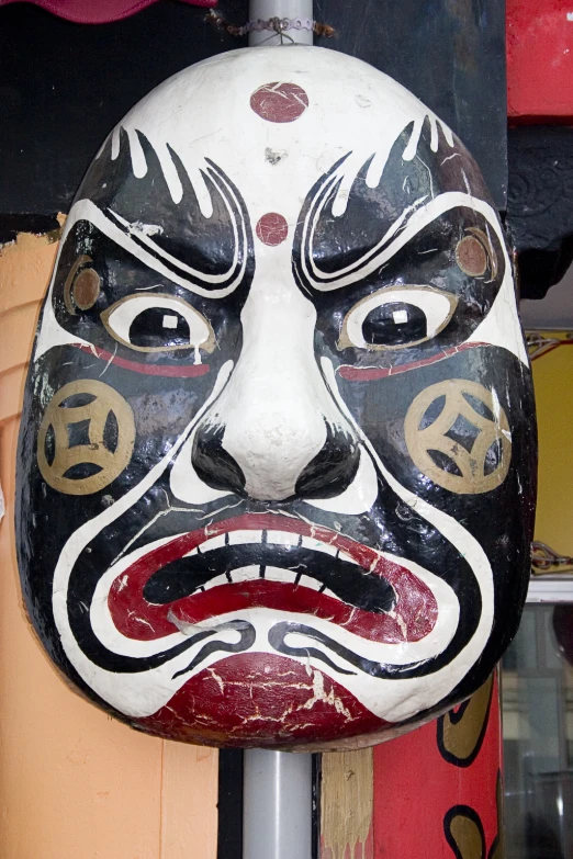 a wooden mask sitting on top of a pole