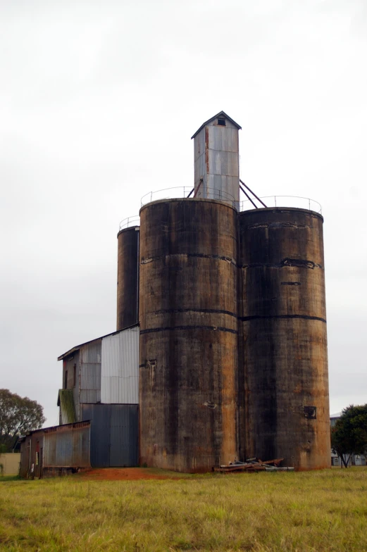 an old, worn out grain storage tower in the middle of the nowhere