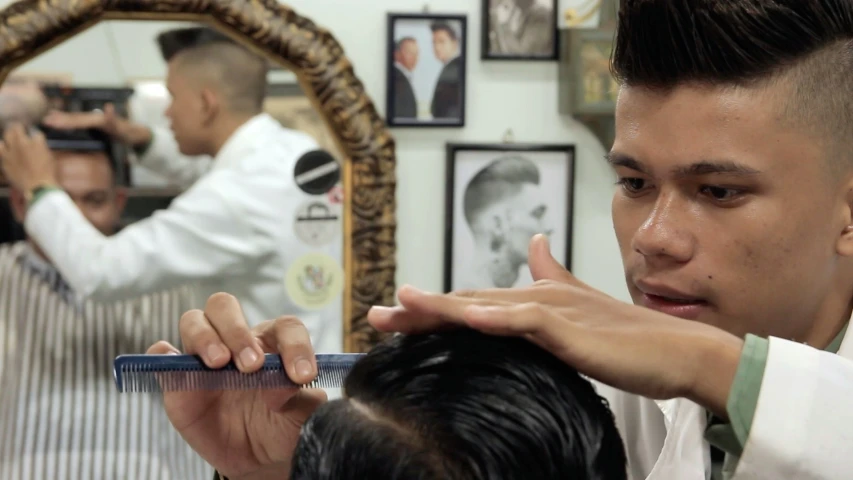 a man is getting his hair cut by a barber