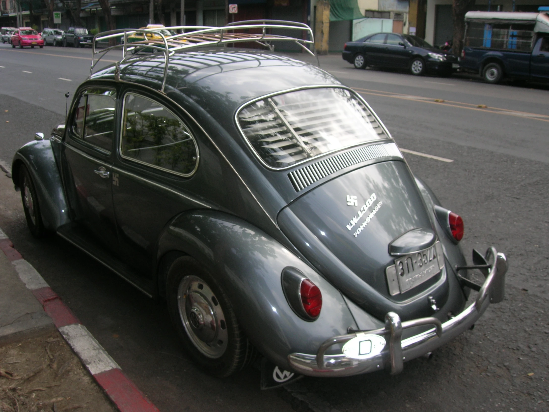 a gray vw bug is parked on the side of the road