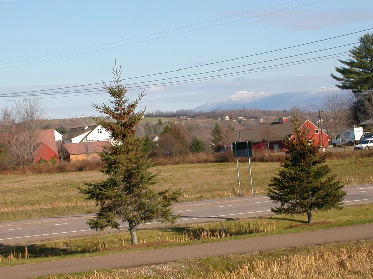 three small houses sit beside the highway on the hill