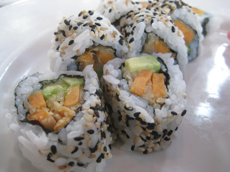 a plate topped with lots of sushi rolls