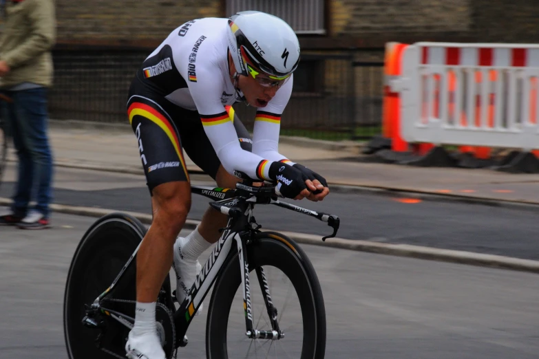 a man in bib shorts and helmet riding a bicycle