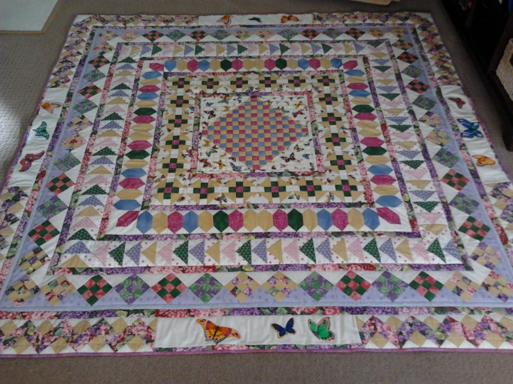 a quilted bed with multi colored details on it