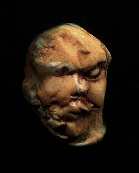 an old mask in the middle of a black background