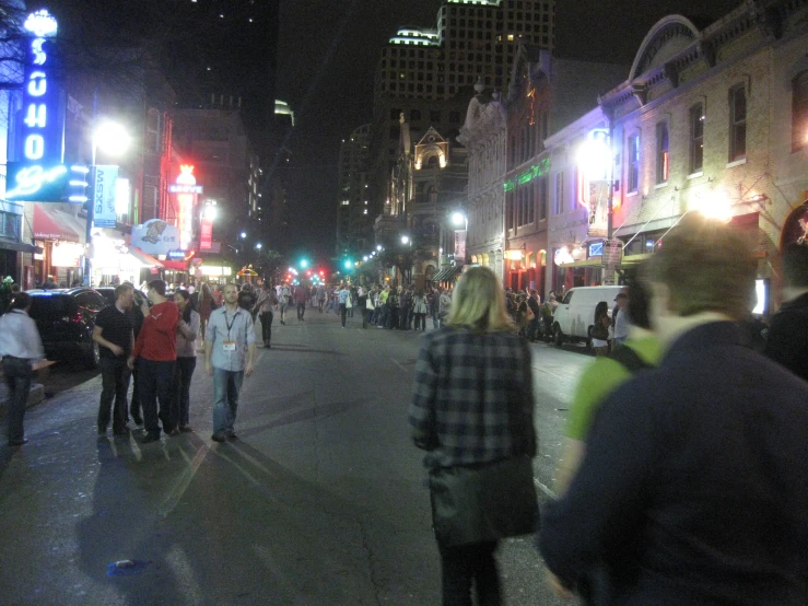 a group of people walking down the middle of the road in an empty street