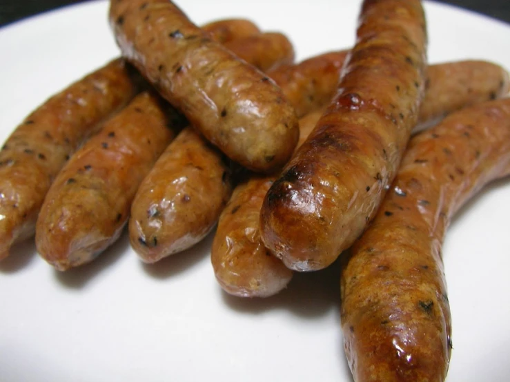 many sausages on a plate have brown spots