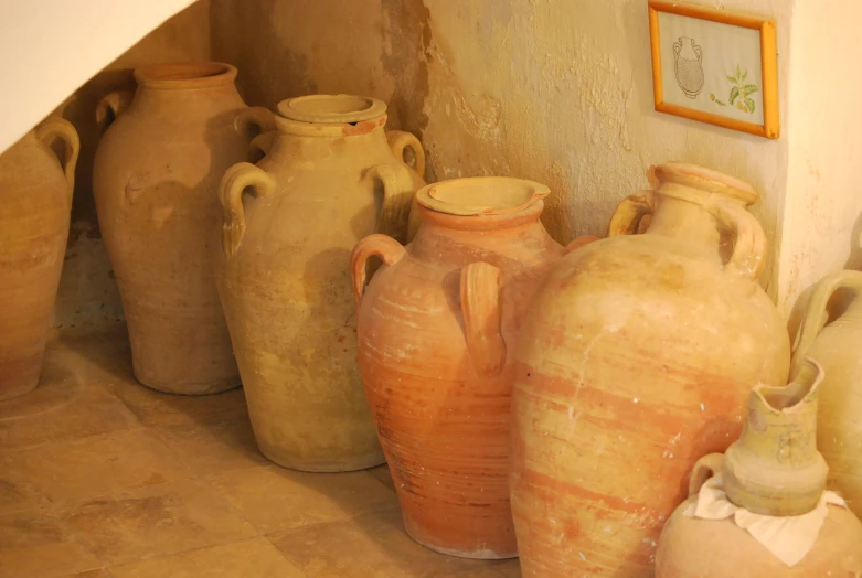 some pottery pots are lined up against the wall