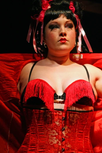 a woman dressed up wearing a red corset and matching jewelry
