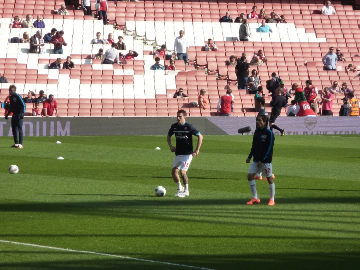 a couple of soccer players standing on a field with a ball