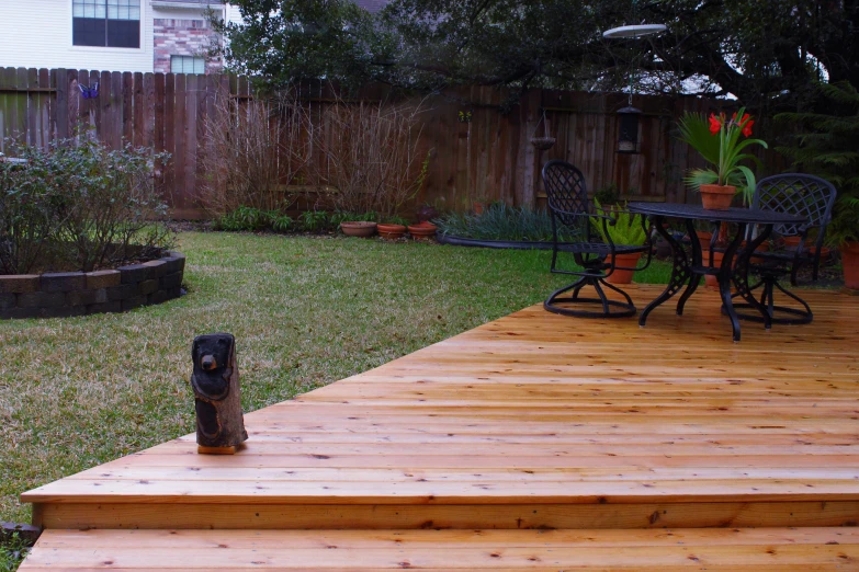 the small backyard has a wooden deck and table