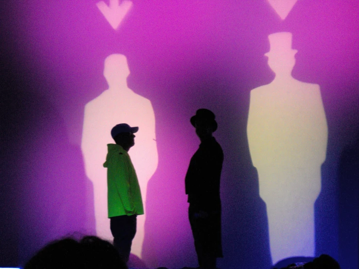 two people shadowed against a wall and shadows on the wall