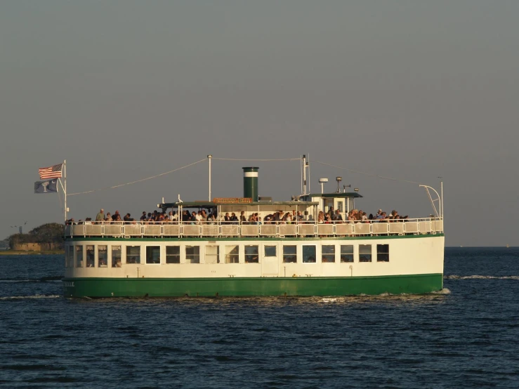 a green and white boat in the middle of the ocean