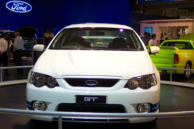 a white car parked on display in a building